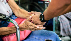 dando la mano de ayuda a una persona en silla de ruedas