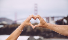 una pareja haciendo un corazon con sus manos